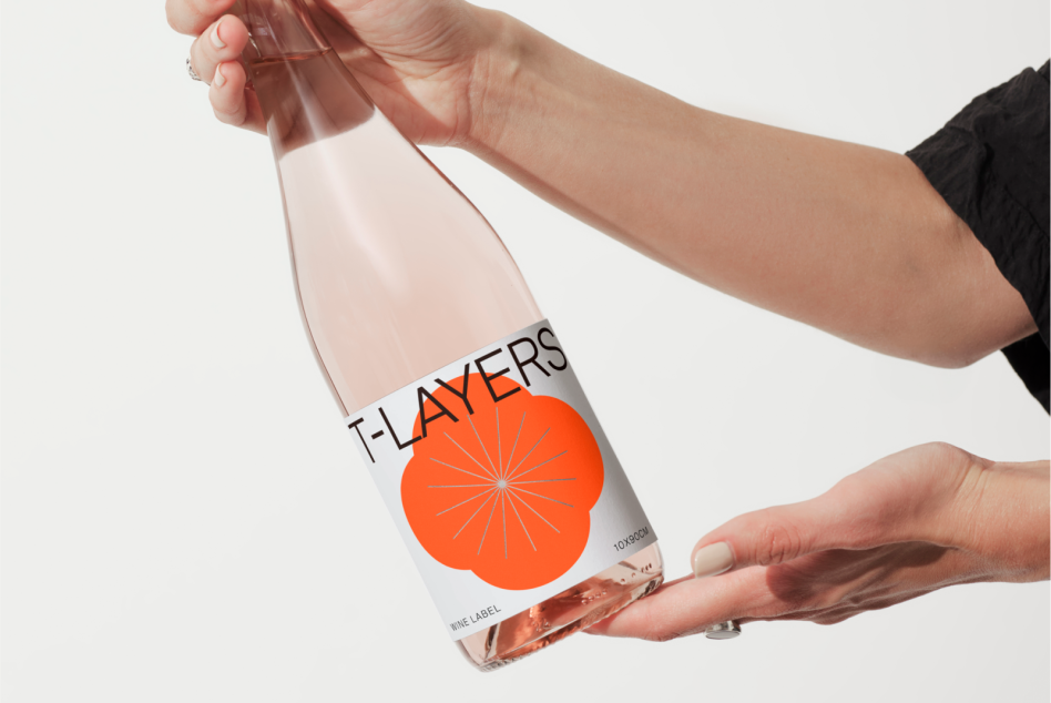 Hands holding a bottle with a modern label design, ideal for mockup graphics and product branding presentations for designers.