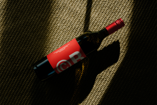 Wine bottle on textured backdrop with unique shadow, perfect for mockup, branding, and packaging designs. Ideal for commercial and advertising projects.