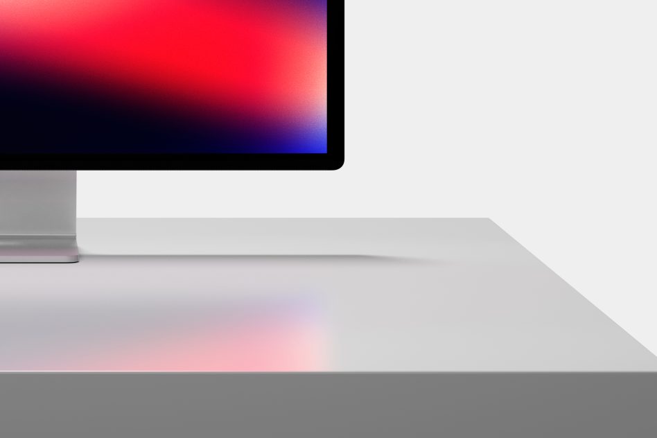 Modern computer monitor mockup on white table with vibrant gradient wallpaper, ideal for web design presentations and tech showcases.