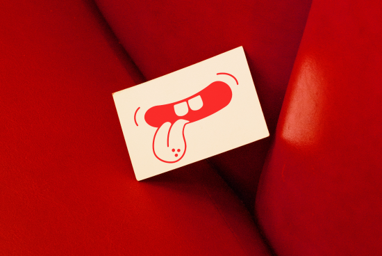Business card mockup with red tongue and lips graphic design on a leather texture background, ideal for branding and presentation visuals.