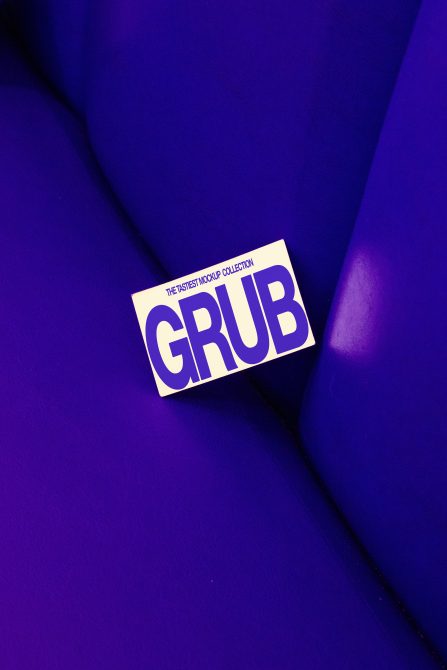 Cream label with bold purple GRUB text on vibrant blue fabric backdrop with dramatic lighting