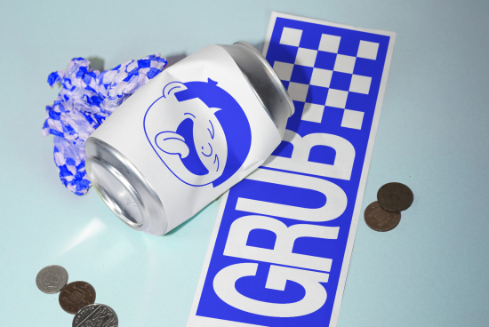 Mockup of an aluminum can with blue logo alongside blue and white branded paper and scattered coins, perfect for product design presentations.