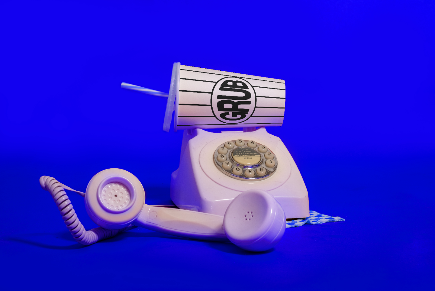 Vintage white rotary phone with oversized fast food cup, creative mockup on blue background, ideal for quirky advertising, pop art design elements.