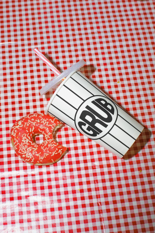 Stylized fast-food cup and donut on red checkered background for realistic mockup, perfect for design presentations and visual assets.