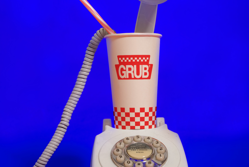 Creative mockup of retro white rotary phone with modern branded paper cup and straw on vibrant blue background, concept design, pop art style.