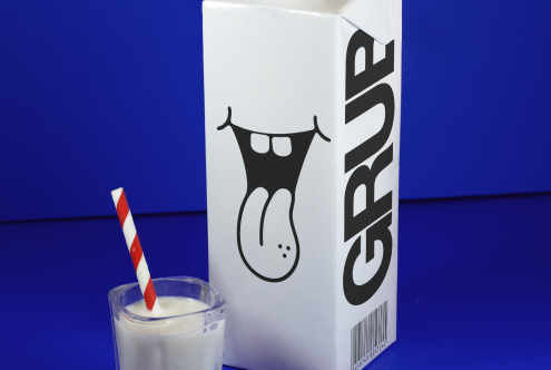 Creative milk carton packaging mockup on blue background with glass of milk and striped straw, ideal for product design and branding.