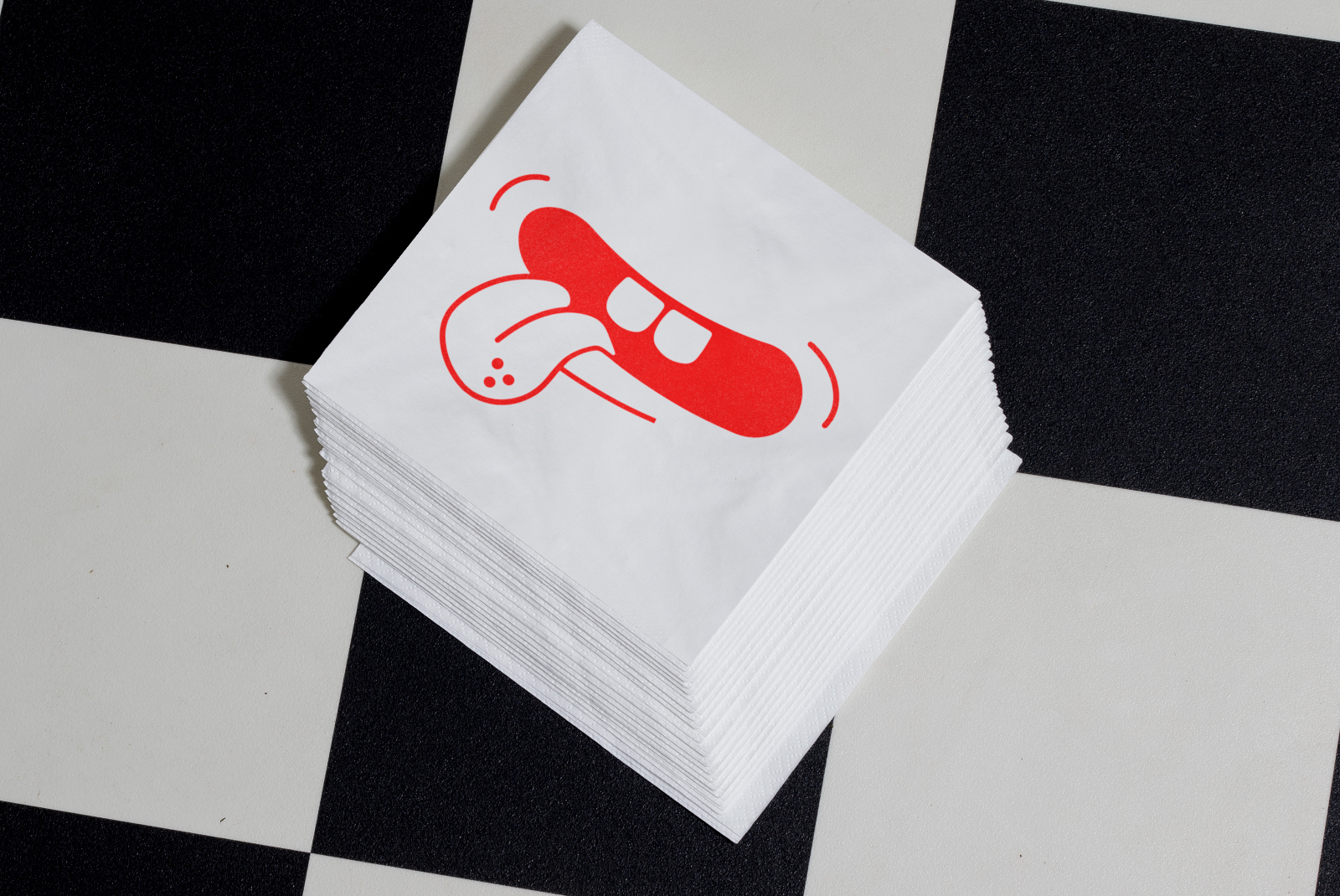 Stack of white napkins with red artistic design on geometric black and white background, ideal for mockup, design assets, napkin design display.