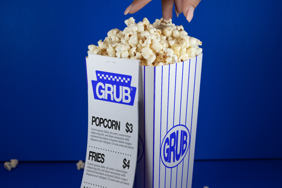 Hand reaching into a striped popcorn box, mockup design for snack packaging, food branding, graphic print, blue background.