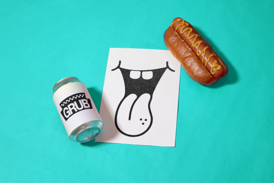 Flat lay of pop art illustration with tongue graphic, canned drink mockup, and hot dog on teal background.