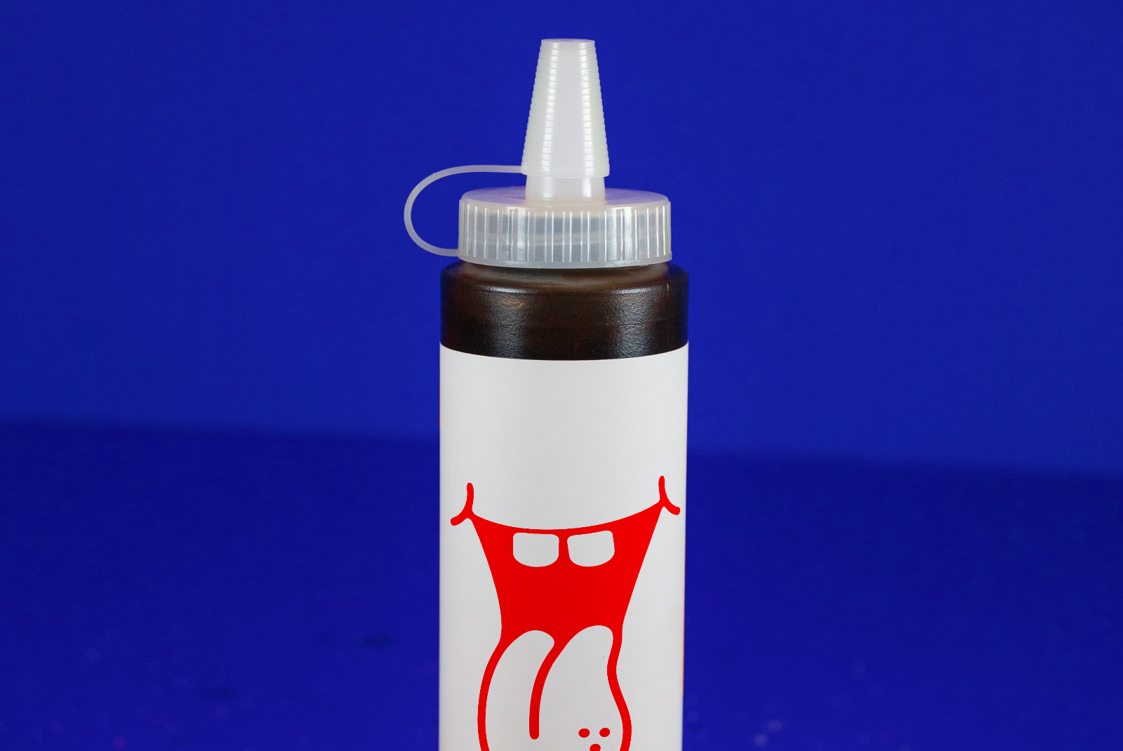 High-quality mockup of glue bottle with red label design on blue background, perfect for presentations and product branding.