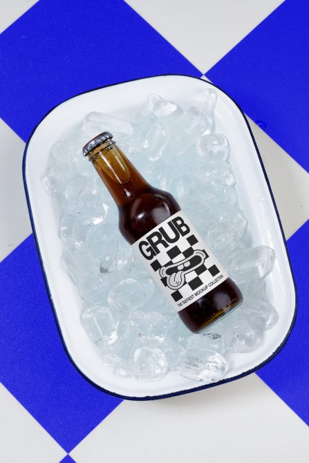 Beer bottle mockup sitting in ice on white tray with bold blue geometric background