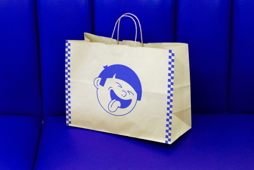 Paper shopping bag with blue cartoon branding on blue background, mockup for logo presentation, design assets for packaging.