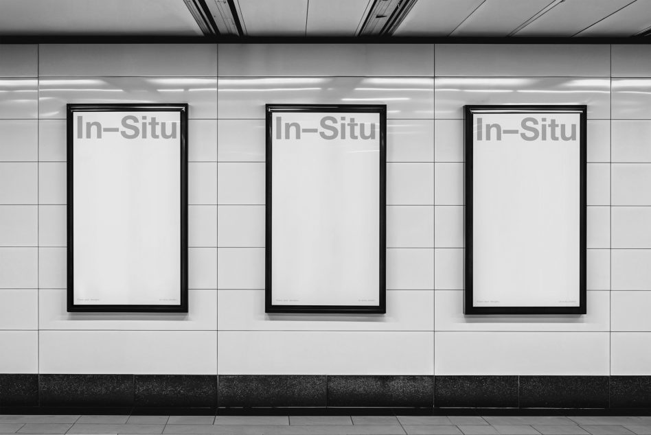 Three black framed posters on clean white subway tiles with fluorescent lighting overhead
