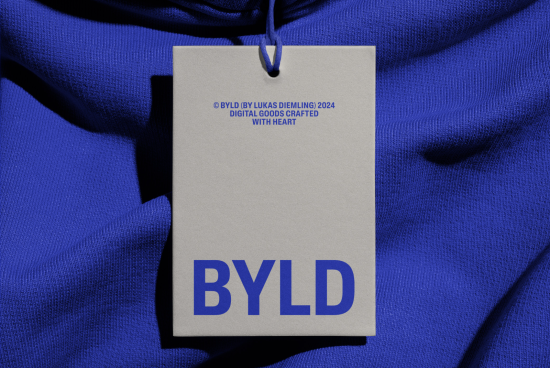 High-resolution clothing tag mockup on blue fabric showcasing logo and text for branding, suitable for graphics and templates.