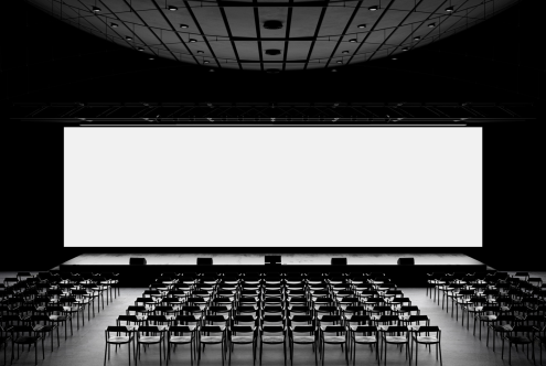 Empty conference hall with rows of chairs and large projection screen, ideal for mockup, presentation template, and event design background.