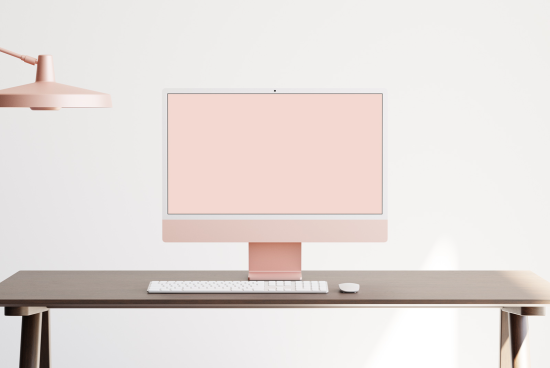 Modern computer mockup on wooden desk with pink lamp, ideal for website design showcase, minimalist workspace graphic presentations.