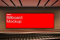 Wide red billboard mockup mounted on wood paneling with track lighting
