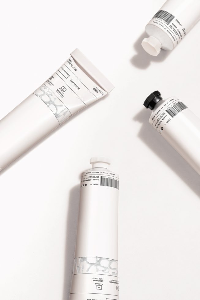 Cosmetic tubes mockup with clean design and white labels on a plain background, perfect for branding and packaging design presentations.