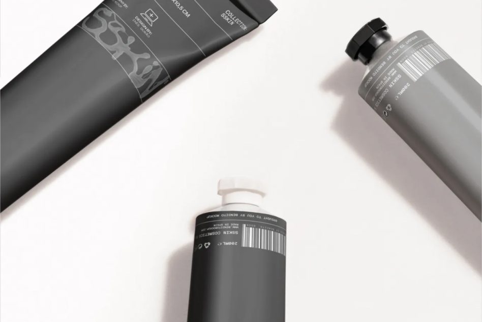 Dark gray beauty product tubes with white accent packaging shot from overhead