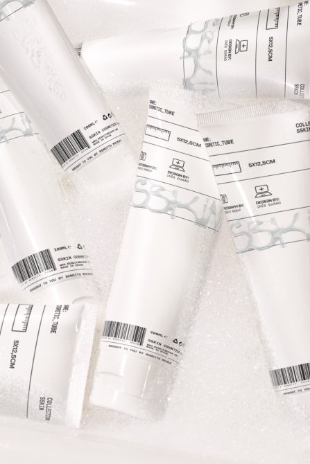 Mockup of white cosmetic tubes with labels submerged in sudsy water, ideal for beauty product branding presentations.