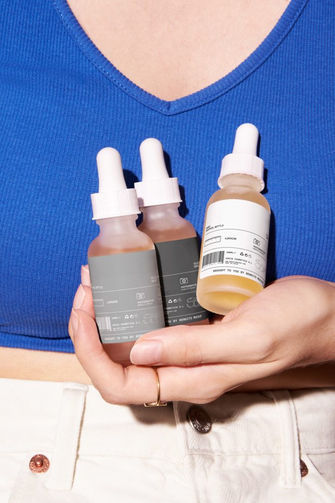 Person holding skincare bottles with minimalist labels, ideal for beauty product mockup designs, packaging presentation, and cosmetics branding.