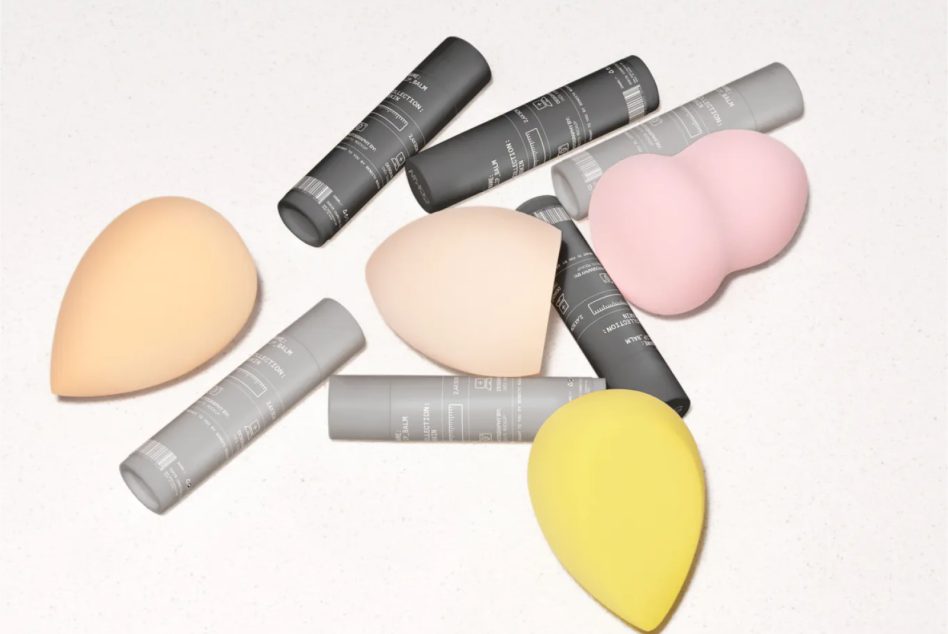Black grey white spray bottles styled with colorful beauty blender sponges flat lay