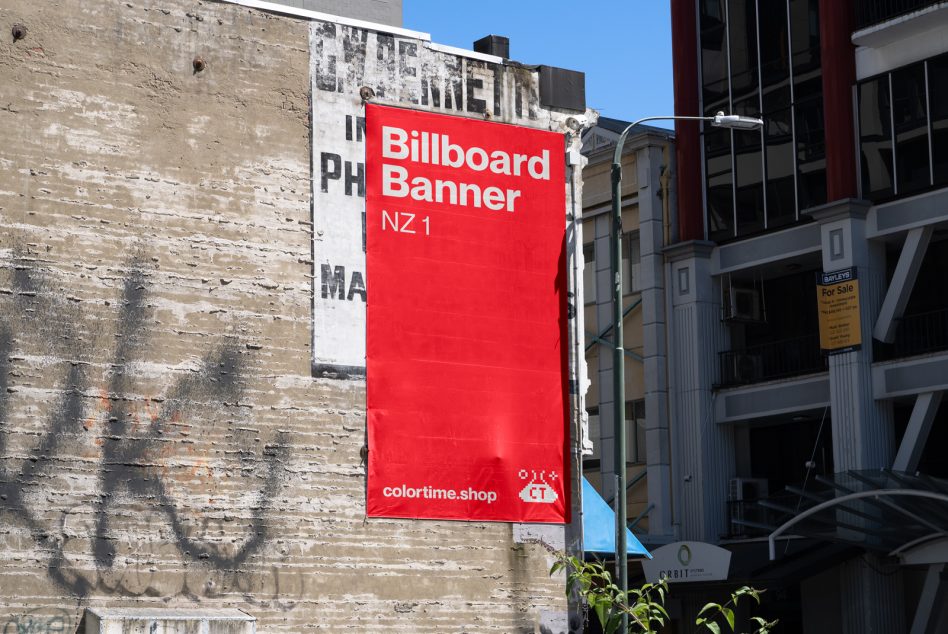 Urban billboard banner mockup hanging on a weathered building wall, clear sky, ideal for branding presentation, advertising design.