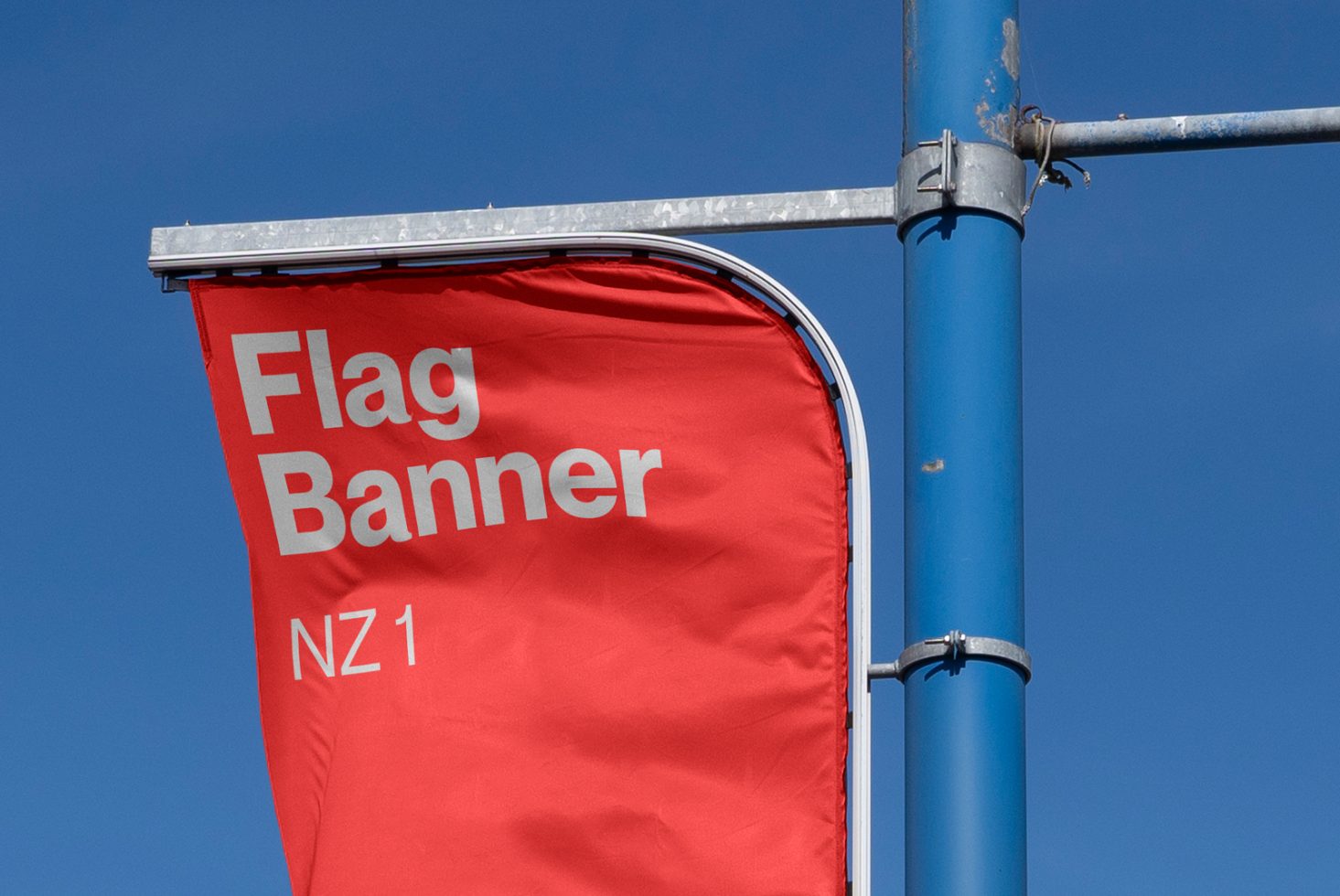 Red flag banner mockup on pole, clear blue sky background, outdoor advertising design, display template, designers asset.