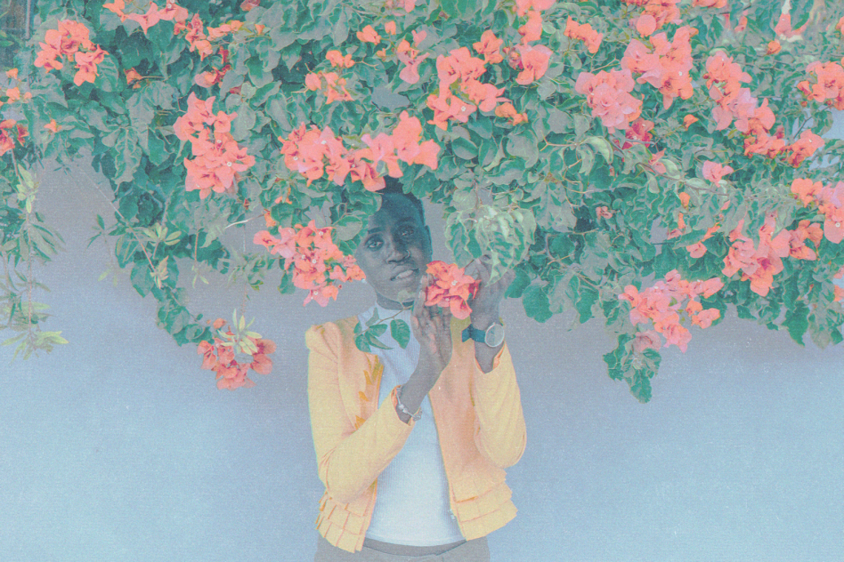 Woman in yellow blazer posing with pink flowers for a spring fashion photo template.