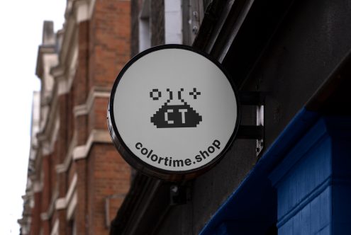 Circular shop sign mockup with pixelated design on urban building facade for branding and logo presentation.