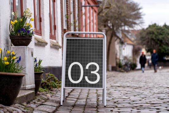 Urban street signage mockup with grid design and bold number 03 displayed, surrounded by European architecture and cobblestone path.