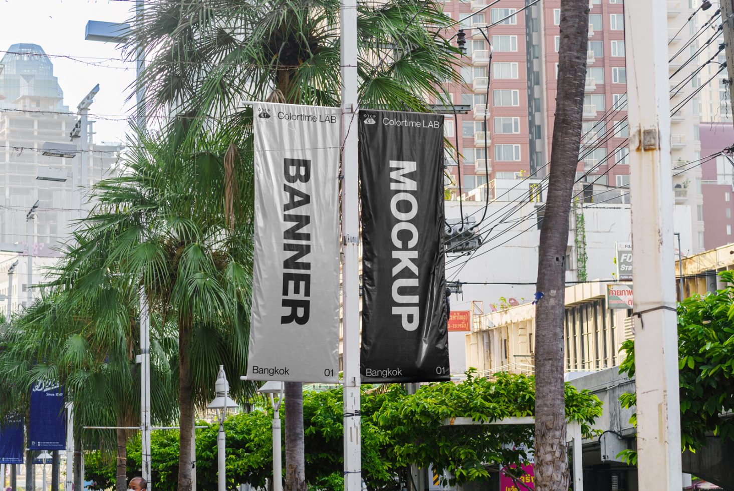 Outdoor vertical banner mockup designs hanging in urban setting with lush greenery for graphic display, marketing, and branding presentation.