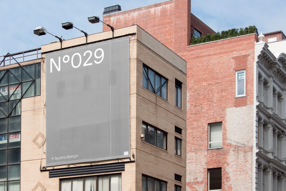 Light gray billboard on mixed brick buildings displaying N°029 branding