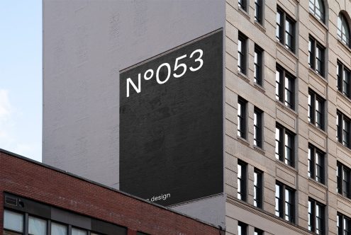 Urban building wall billboard mockup with minimalist magazine layout design for showcasing typography and graphics in a realistic setting.