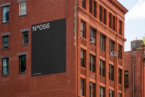 Urban building wall with a mockup black billboard for advertising design, clean textures, editable graphic design template.