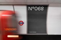 Underground station poster with dark background, Tottenham Court Road logo, bus blur