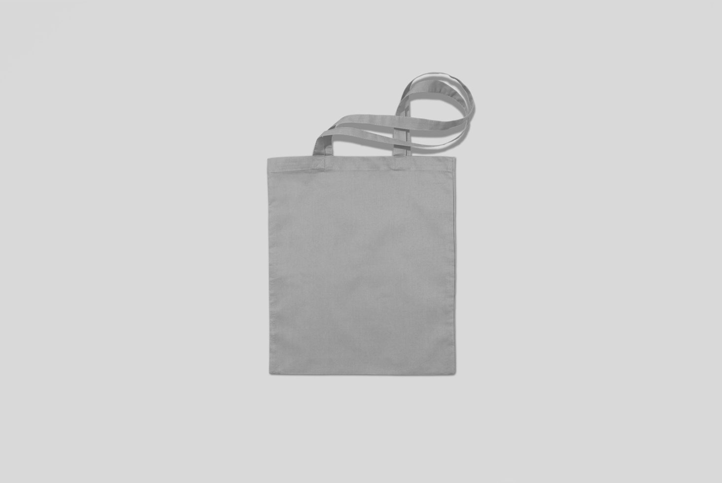 Plain tote bag mockup with gray fabric texture on an isolated white background for design presentation.