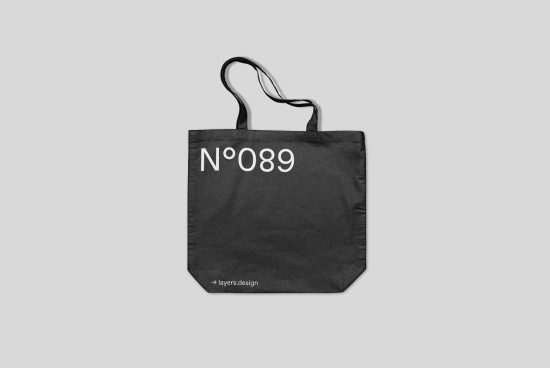 Black tote bag mockup with white text design No 089 on a plain background, versatile asset for graphic designers.