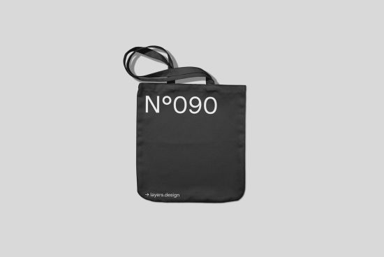 Black tote bag mockup with minimalist number design on a gray background, perfect for eco-friendly packaging presentations and graphic designs.