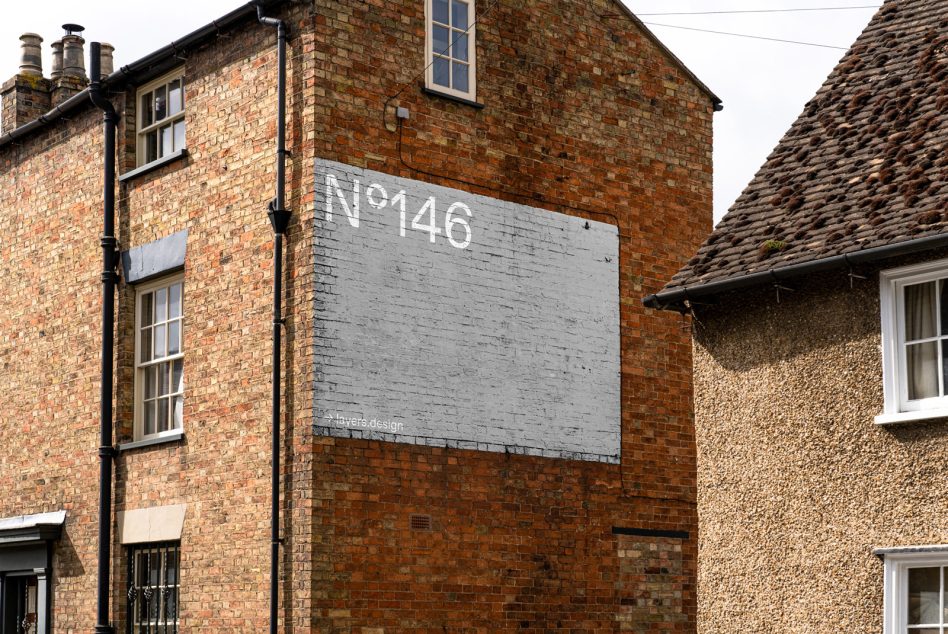 Painted brick wall sign mockup displaying N°146 on residential building