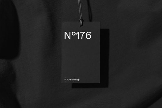 Elegant black clothing tag mockup on fabric, showing design space for branding, realistic shadows, ideal for graphic designers to showcase work.