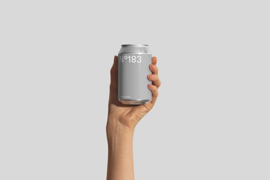 Hand holding a blank aluminum can mockup for branding and packaging design on a plain background.
