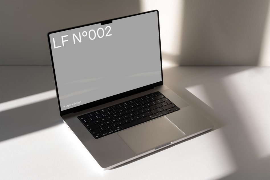 Laptop mockup at angle showing LF N°002 on gray screen in modern workspace