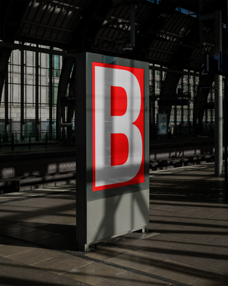 Urban billboard mockup at a train station with a large red letter B, ideal for showcasing designs, fonts, and graphic advertising to designers.