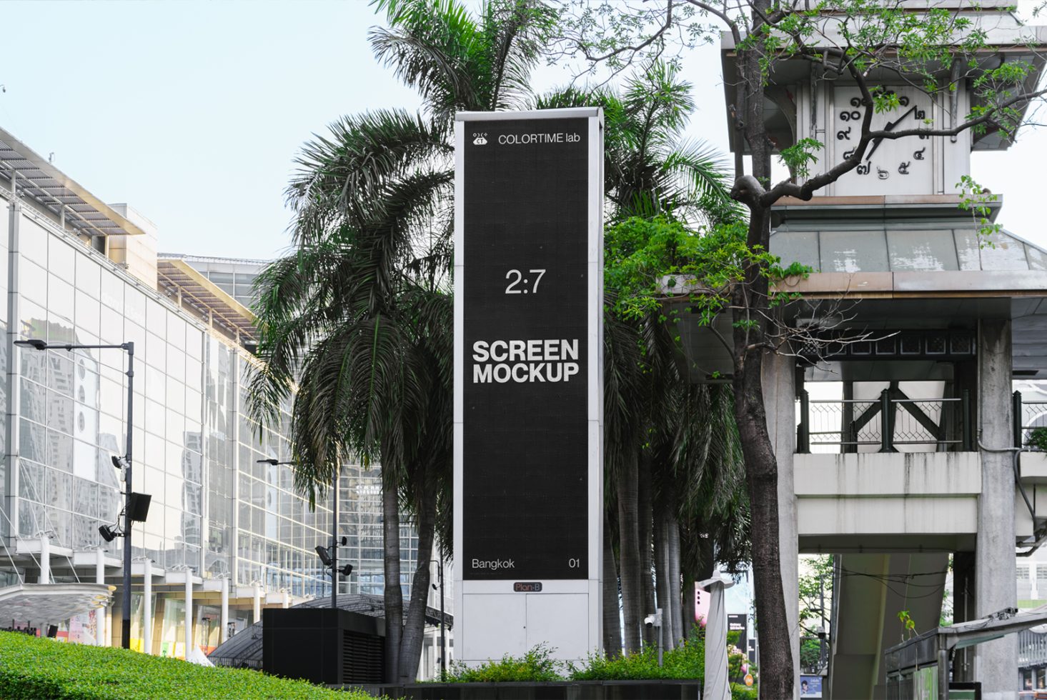 Urban vertical billboard mockup on a sunny day with surrounding palm trees, reflecting building, and city walkway for outdoor advertising designs.