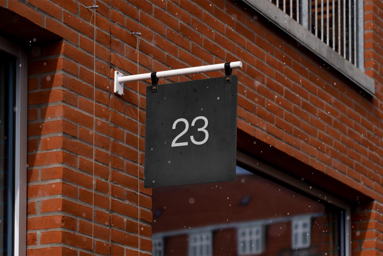 Elegant black hanging signboard with white number 23 on a red brick wall background, ideal for mockup designs and templates.