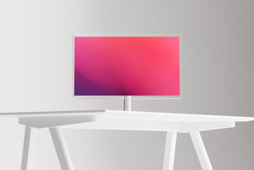 Minimalist computer monitor with vibrant gradient screen on white desk, ideal for website mockup, digital design presentations.