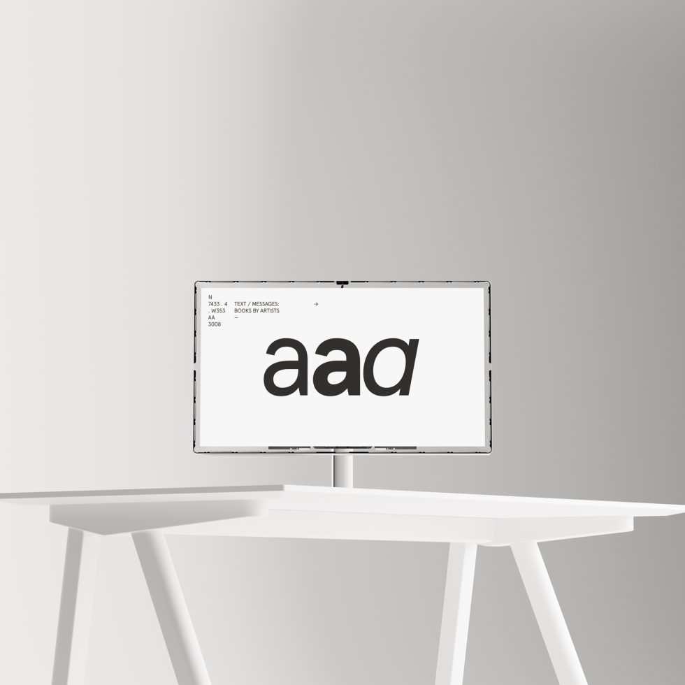 Minimalistic computer monitor mockup on white table showcasing bold font design, ideal for graphic design presentations and typographic layouts.