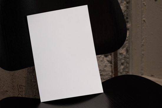 Blank vertical paper mockup on black chair, textured background, design presentation, print mockup, graphic assets.