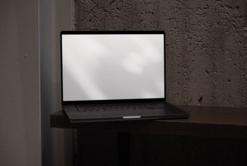 Laptop on desk with blank screen for mockup design display, sleek device in a modern setting, ideal for tech presentations.